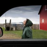 Serene female farmer standing outside truck on farm By Hero ImagesHero Images.jpg